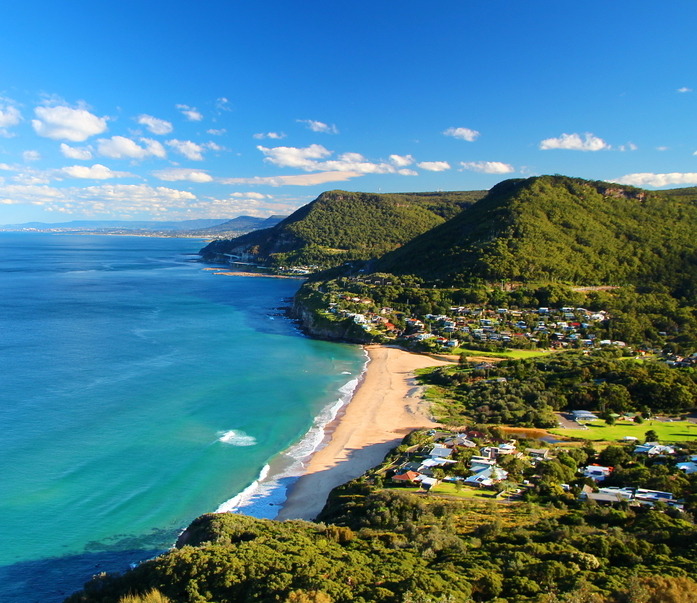 Illawarra coastline with a sandy beach, turquoise water and escarpment bushland above Stanwell Park